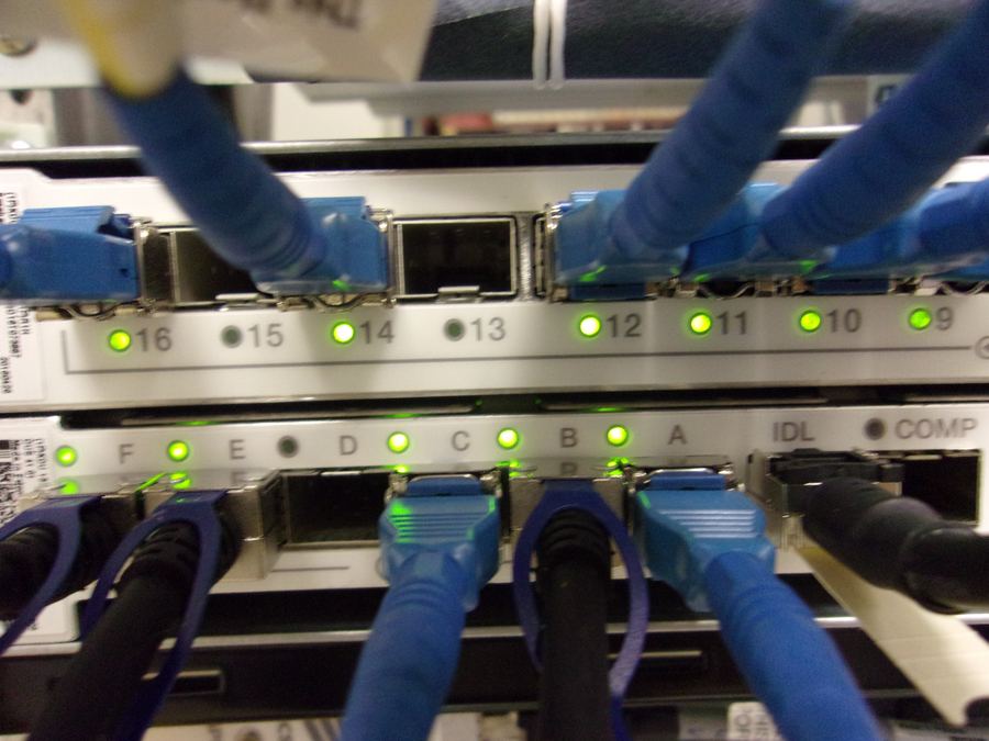 Equipment rack with blue fiber patch cables and green status lights